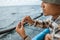 angler puts bait on a hook while casting at sea