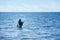 An angler in waders is fishing on the Baltic Sea coast in MiÄ™dzyzdroje