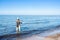 An angler in waders is fishing on the Baltic Sea coast in MiÄ™dzyzdroje