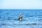 An angler in waders is fishing on the Baltic Sea coast in MiÄ™dzyzdroje