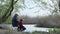 Anglers, an elderly man with little boy catch fish using a wooden fishing rod sitting on shore