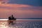 Anglers` silhouettes on a fishing stand at sunset at Lake Balat