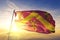 Anglesey county of Wales flag textile cloth fabric waving on the top sunrise mist fog