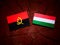 Angolan flag with Hungarian flag on a tree stump isolated