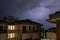 Angri, Italy. Striking lightning illuminates the night sky above houses at night during a summer thunderstorm