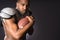 Angry African American Male Football Player Holds Ball Tight