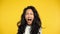 Angry asian woman screaming on yellow background