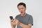 Angry Asian young man get mad on the smartphone. Indonesia Man wear black shirt Isolated grey background