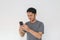 Angry Asian young man get mad on the smartphone. Indonesia Man wear black shirt Isolated grey background