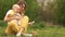 Angry baby in the arms of her mother. The baby is crying, mom calms. Woman and baby on a picnic in the park