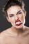 angry beautiful woman holding dollar banknote in teeth