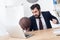 angry businessman with basketball ball at workplace