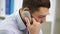 Angry businessman calling on phone at office