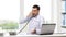 Angry businessman with laptop calling on phone