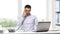 Angry businessman with laptop calling on phone