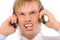 Angry businessman shouts in two phones