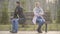 Angry Caucasian man and woman sitting back to back on opposite sides of bench outdoors. Unhappy couple with age