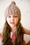 Angry child girl in beige knitted hat