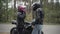 Angry couple of biker arguing outdoors. Irritated young woman taking off pink helmet, giving it to stressed man, and