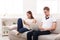 Angry couple quarreling and using gadgets irnoring each other