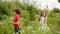 Angry couple teens walk high grass blossom meadow