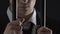 Angry criminal business person standing behind metal bars in prison cell, bribe