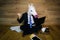 Angry and dissatisfied unicorn in a suit and tie shows fist and works at home office