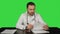 Angry doctor posing at table on a Green Screen