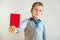 Angry face child showing a red card as a warning, stop bullying concept, blank background