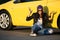 Angry fashion woman in leather jacket sitting at the car