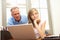 Angry Father And Teenage Daughter Using Laptop At