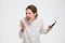 Angry irritated young business woman holding mobile phone and shouting