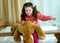 Angry little girl beating her teddy bear - domestic abuse concept. Girl 4-5 year old punishes toy bear