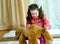 Angry little girl beating her teddy bear - domestic abuse concept. Girl 4-5 year old punishes toy bear