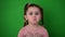 Angry little girl, green background, little girl with pigtails.