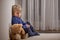 Angry little toddler child, blond boy, sitting in corner with teddy bear, punished