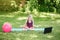 Angry mad girl child doing sport workout outdoor online. Video yoga class on Internet. Funny stressed kid training in park with