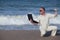 Angry man punching laptop at the beach