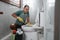 angry man wearing gloves brushing smelly toilet