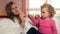 Angry mother and little daughter waving finger looking at camera