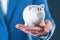 Angry piggy coin bank in businesswoman`s hand