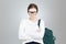 Angry pretty girl student in glasses with backpack