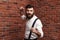 Angry rage young man showing fists posing over brick background.