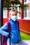 Angry Schoolboy wearing protective mask Standing near school. students are ready for second pandemic wave