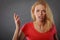 Angry, shocked blonde woman gesturing hands