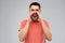 Angry shouting man in t-shirt over gray background