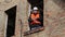 Angry site manager with tablet PC in building\'s second floor window