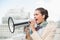 Angry smart brown haired businesswoman screaming in a megaphone