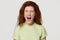 Angry stressed redhead woman screaming yelling loud isolated on background