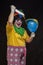 Angry ugly clown wants to kill a balloon in the cap